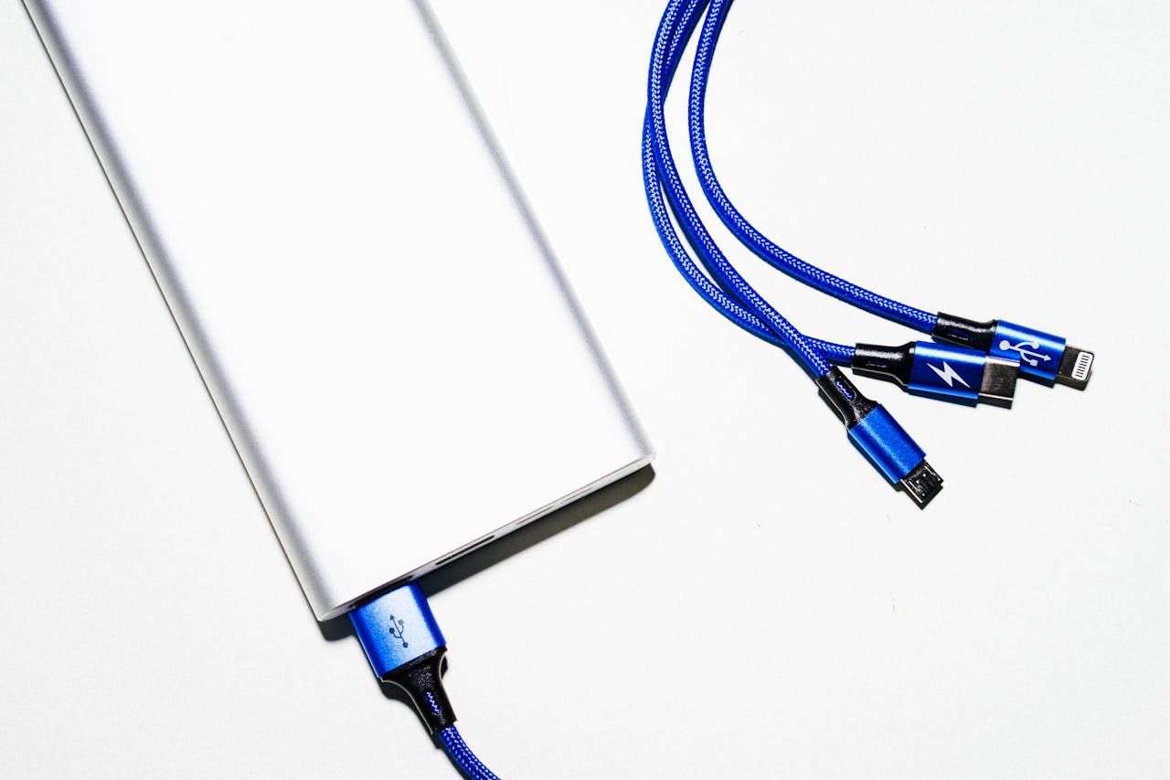 headline Minimalist image of a power bank with blue USB charging cables on a white background.
